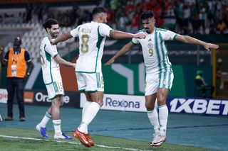 Algeria AFCON 2023 squad; Algeria's forward #9 Baghdad Bounedjah celebrates with teammates afer scoring his team's first goal during the Africa Cup of Nations (CAN) 2024 group D football match between Algeria and Angola at Stade de la Paix in Bouake on January 15, 2024. (Photo by KENZO TRIBOUILLARD / AFP) (Photo by KENZO TRIBOUILLARD/AFP via Getty Images)