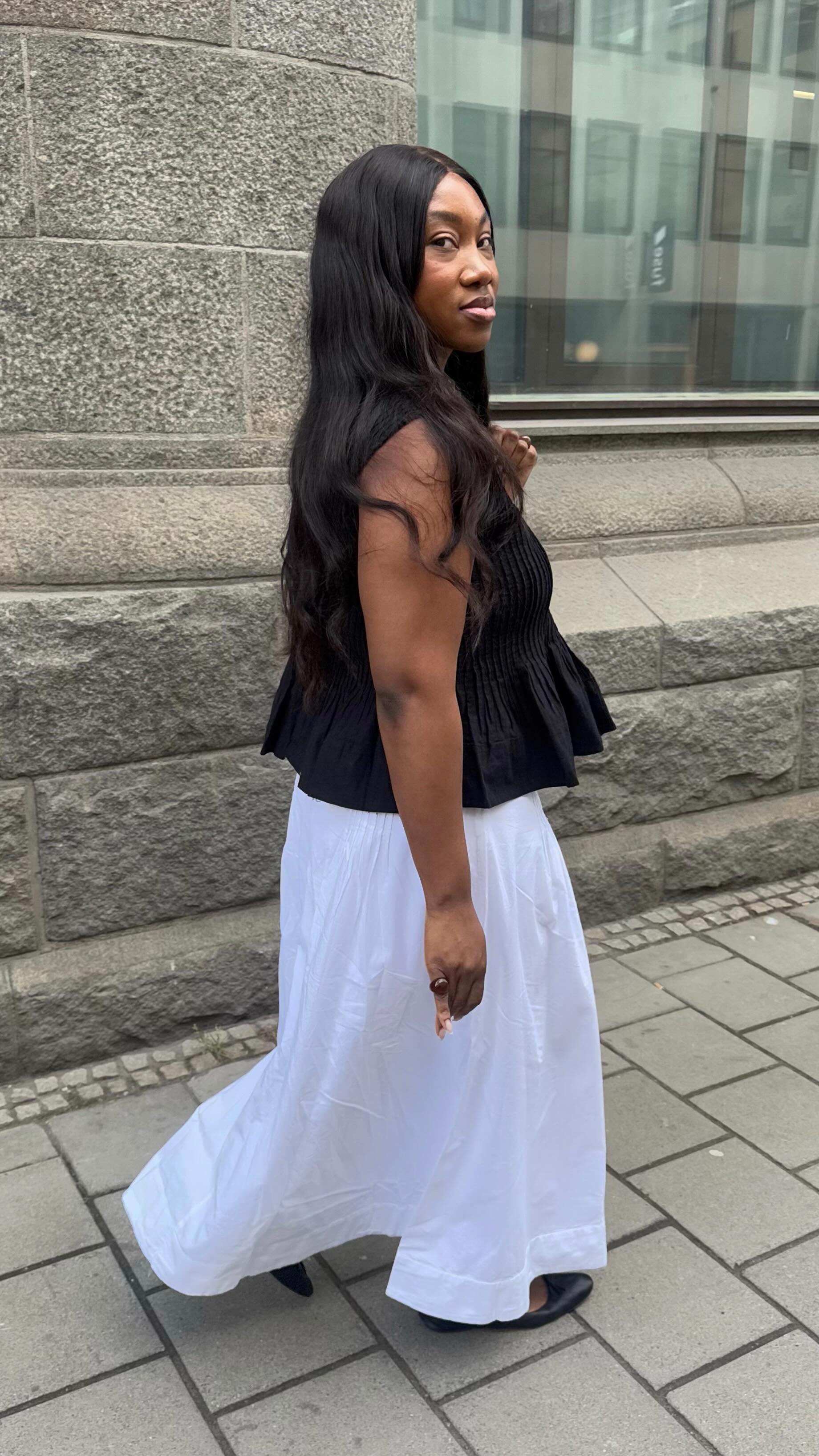 An image of @nnennaechem wearing a pintuck top with a white cotton skirt.