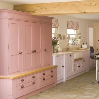 kitchen with cream wall pink cupboard and sink