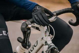 Image shows a rider wearing gloves to avoid cold hands while cycling.