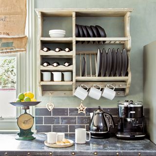 kitchen wooden shelve with cups and plates marble counter with coffee machine weighing machine