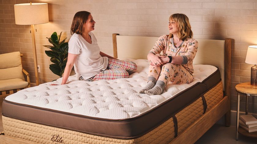 Two Tom&#039;s Guide mattress testers sat on the Helix Midnight Elite mattress