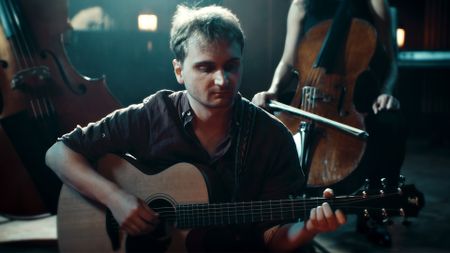 Composer Lorien Testard plays guitar in a live performance of Clair Obscur: Expedition 33's music