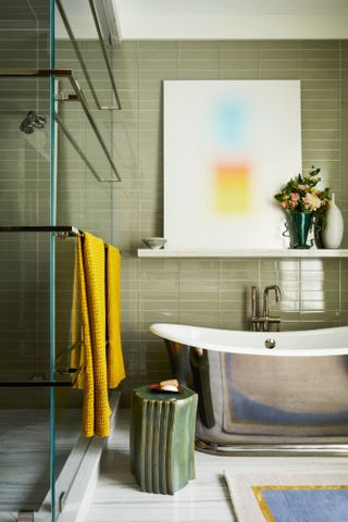 Green tiled bathroom with steel tub and green ceramic stool