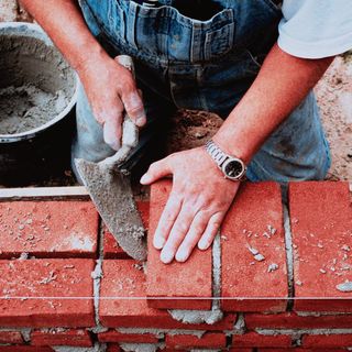 labourer cementing bricks