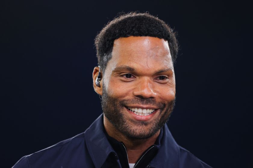 Joleon Lescott smiles during his punditry with TNT Sports 