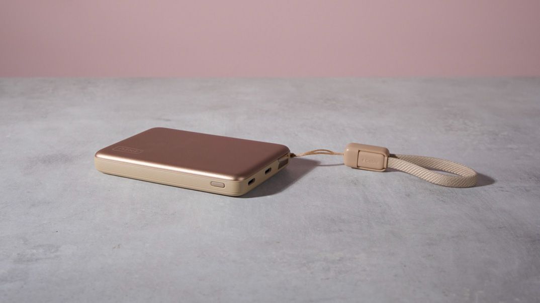 The Iniu SnapGo Air 10000mAh Power Bank laying flat on a table with its handle laying across to the right.