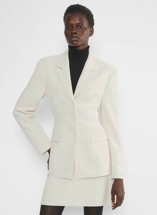 aritzia model wearing white blazer and white skirt