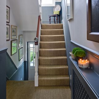 hallway with blue shaded wall and brown staircase