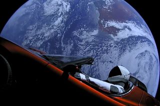 SpaceX's Starman mannequin is seen inside Elon Musk's red Tesla Roadster with Earth in the background, shortly after launch on Feb. 6, 2018. As of Nov. 2, the duo were beyond the orbit of Mars.
