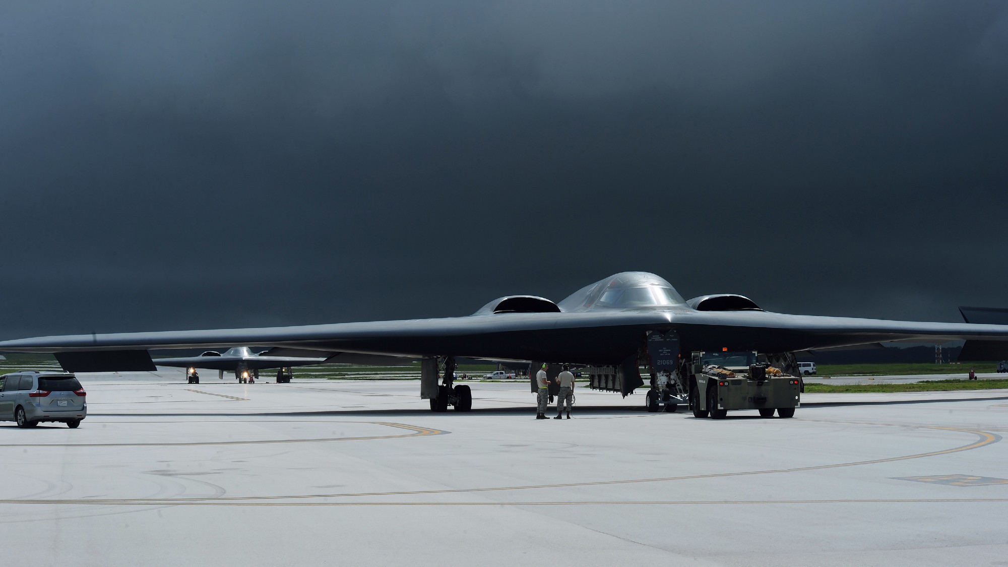 American B-2 Spirit bombers gathered on an airstrip below black clouds