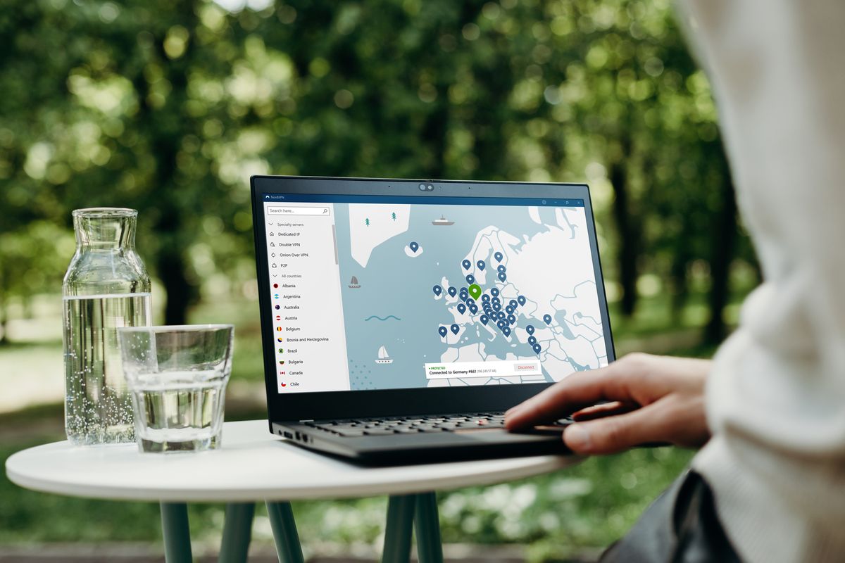 Someone using the NordVPN Windows desktop app on a laptop while sat in a park