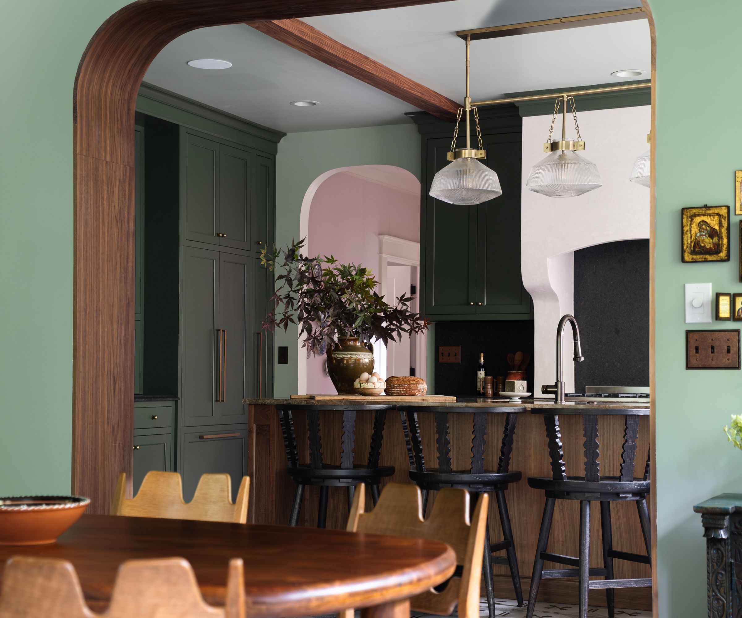 Craftsman kitchen with green cabinets, green walls, and a wooden island