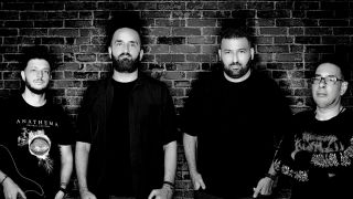 Falling Leaves stood against a brick wall looking serious