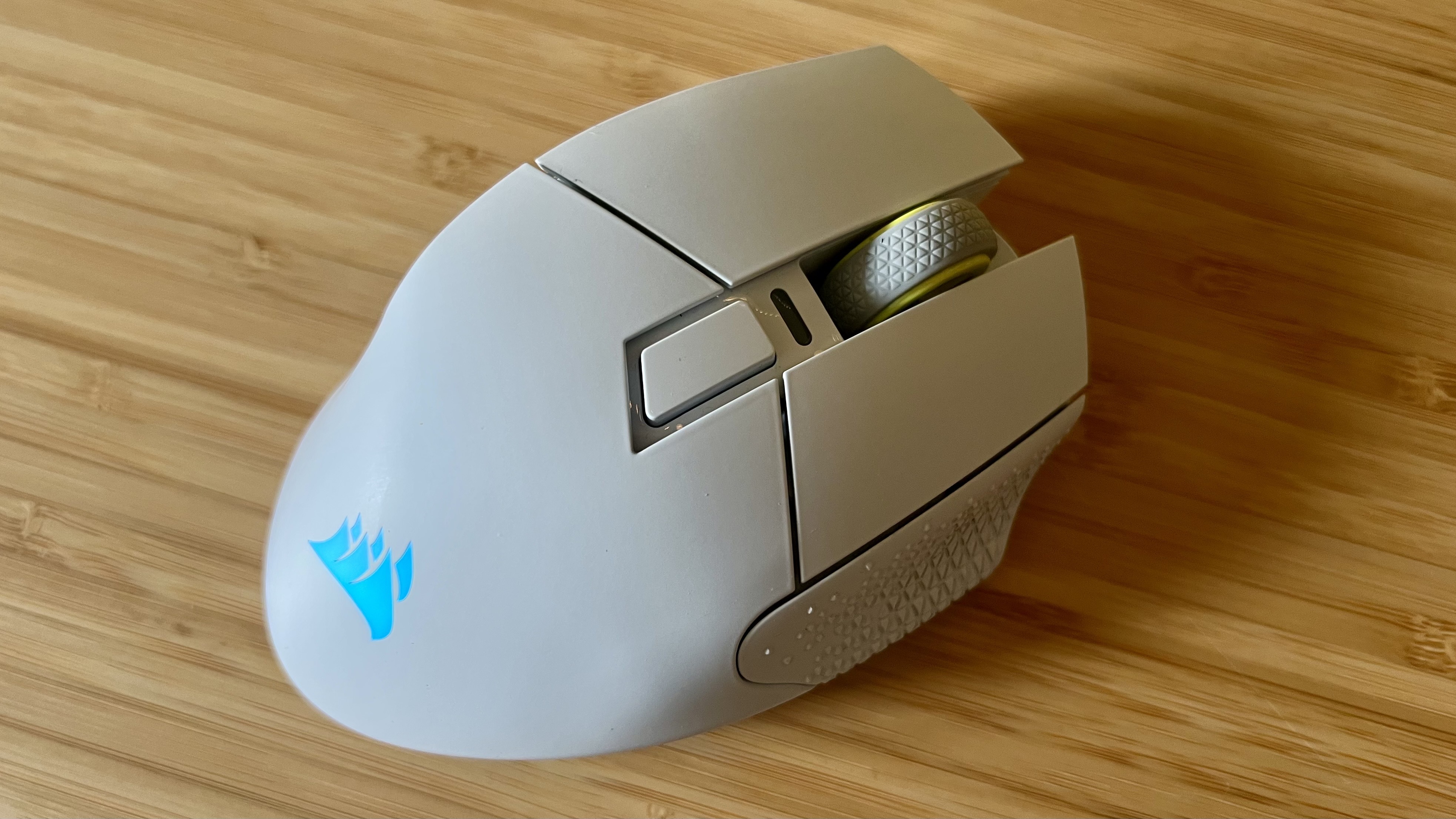 Corsair Scimitar Elite Wireless SE gaming mouse with blue RGB enabled on a wooden desk