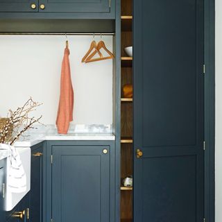 utility area with deep blue cabinets with white surfaces