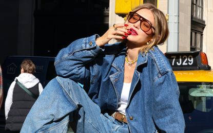 Gigi Hadid sitting on a taxi wearing lipstick