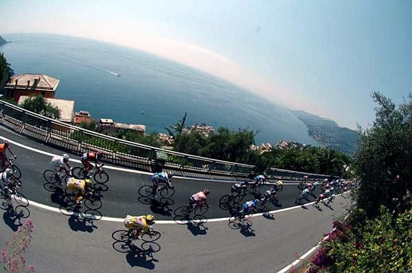 The peloton rides past stunning coastal views