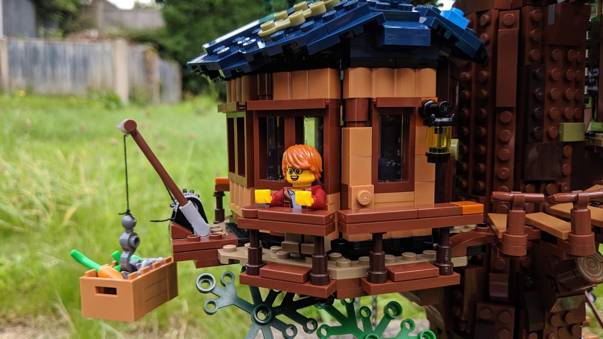 Lego Ideas Tree House 21318 - close up of Lego man using winch on tree house.