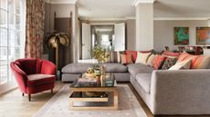 Living room with large L shaped sofa dressed with orange and bro