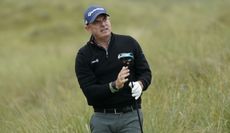 McGinley watches his tee shot with a driver in his hand