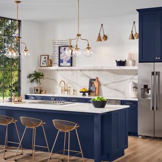 A kitchen with wooden floors, dark blue cabinetry, and white walls