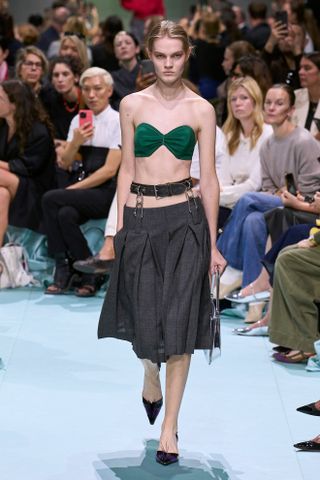 Model wears a pleated skirt on the Prada SS25 runway