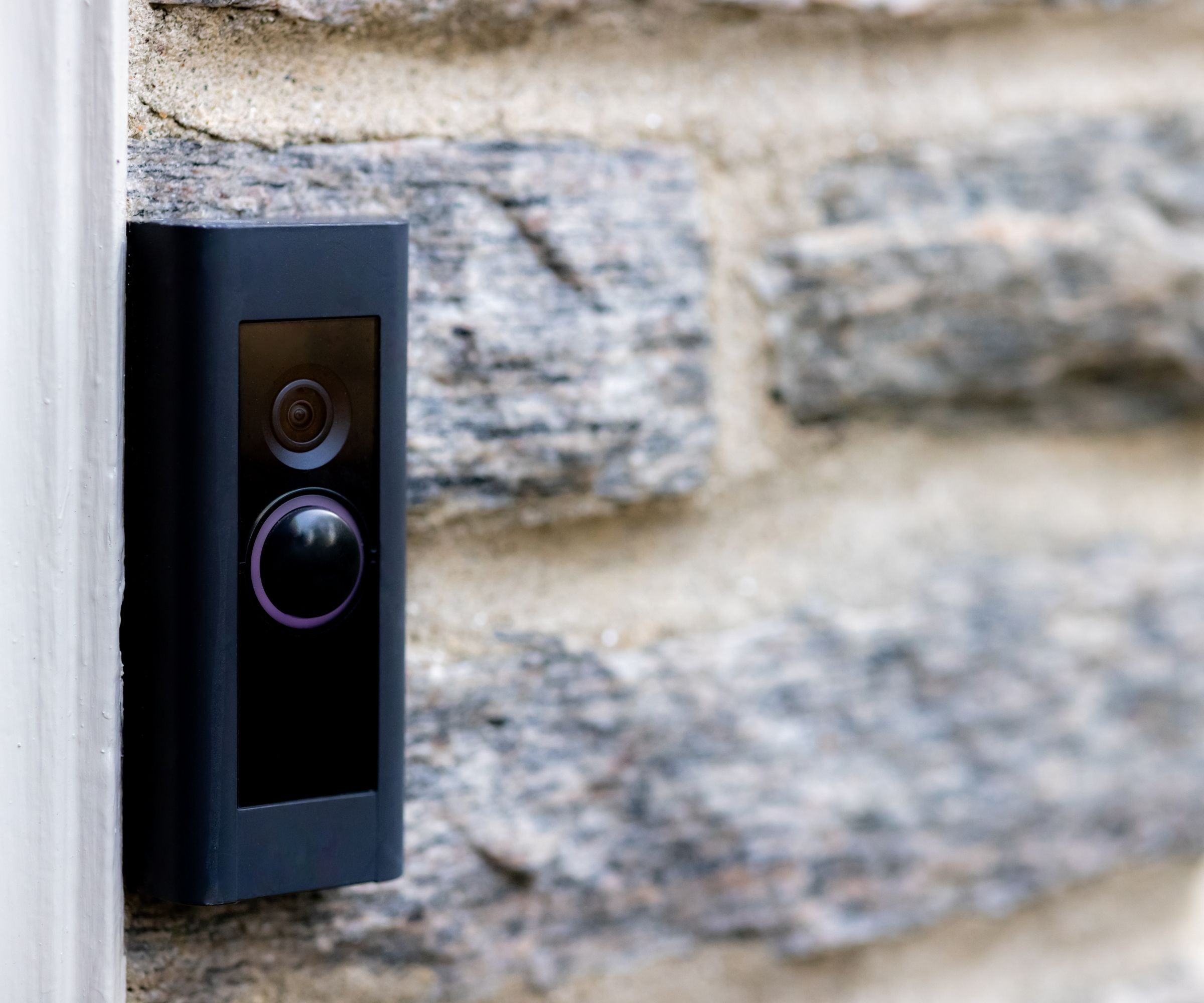 A video doorbell on the side of a stone wall