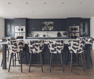 Black kitchen cabinets with black kitchen island and white countertops