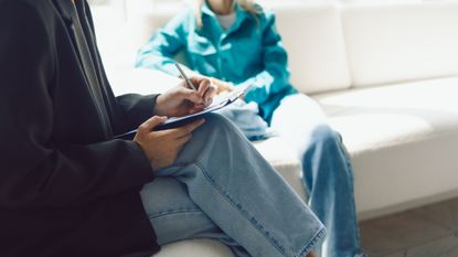 Two women sitting in armchairs and talking. Female coach, psychotherapist, psychologist, advisor and patient, client, psychotherapy, job interview - stock photo