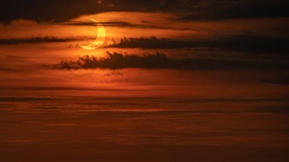 The sun rises during a solar eclipse as seen from The Edge observatory deck at The Hudson Yards on June 10, 2021 in New York City.