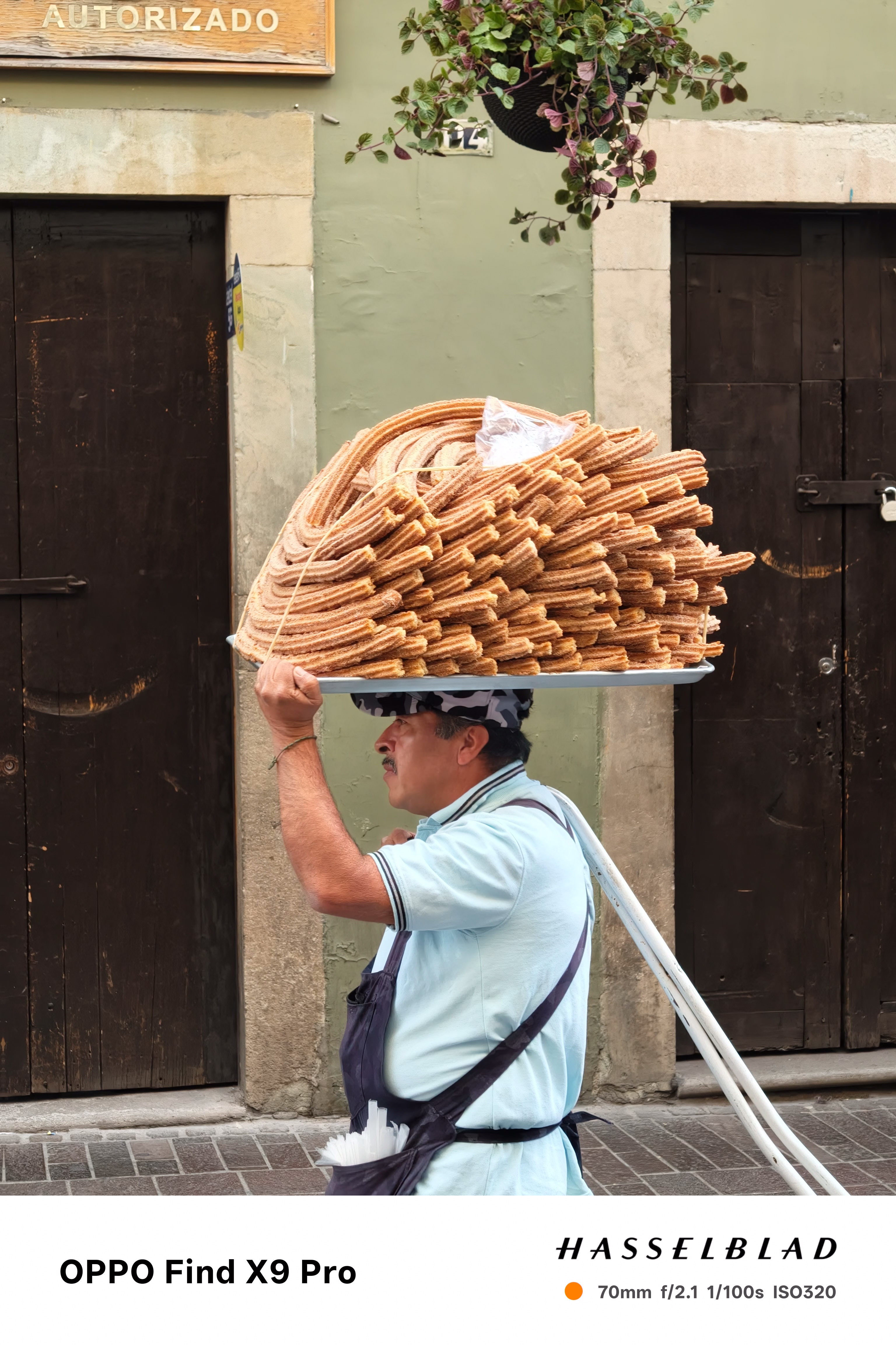 A man carrying a large plate of churros on his head