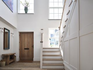 white hallway with wooden floor and staircase