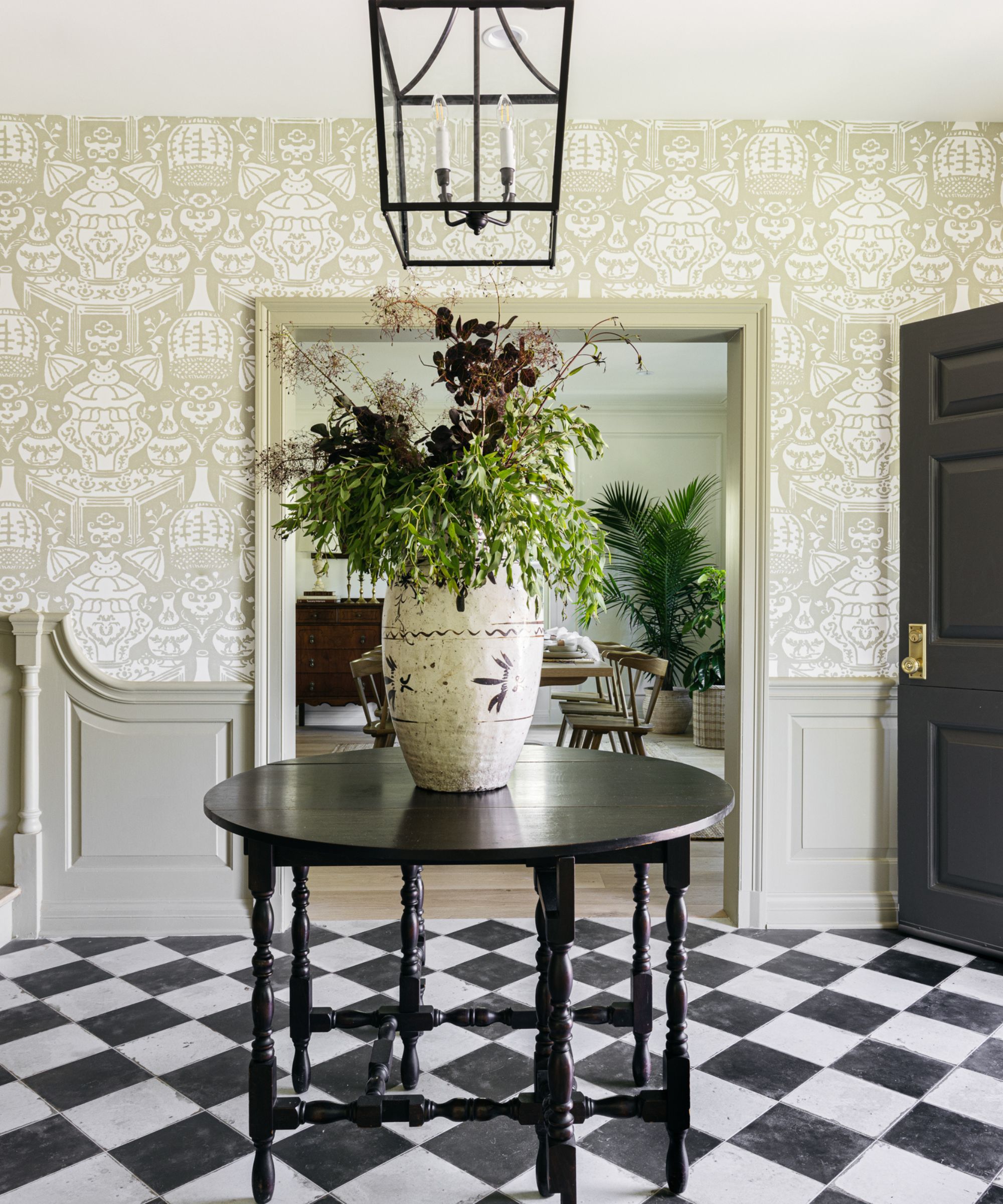 green wallpapered entryway with tiled monochrome floor
