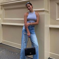 @sasha.mei wearing jeans and a vest top