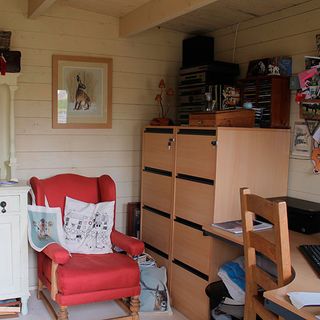 shed with wooden wall and desk and red arm chair