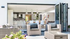 Open bifold doors creating an indoor outdoor space between the kitchen diner and the patio seating area