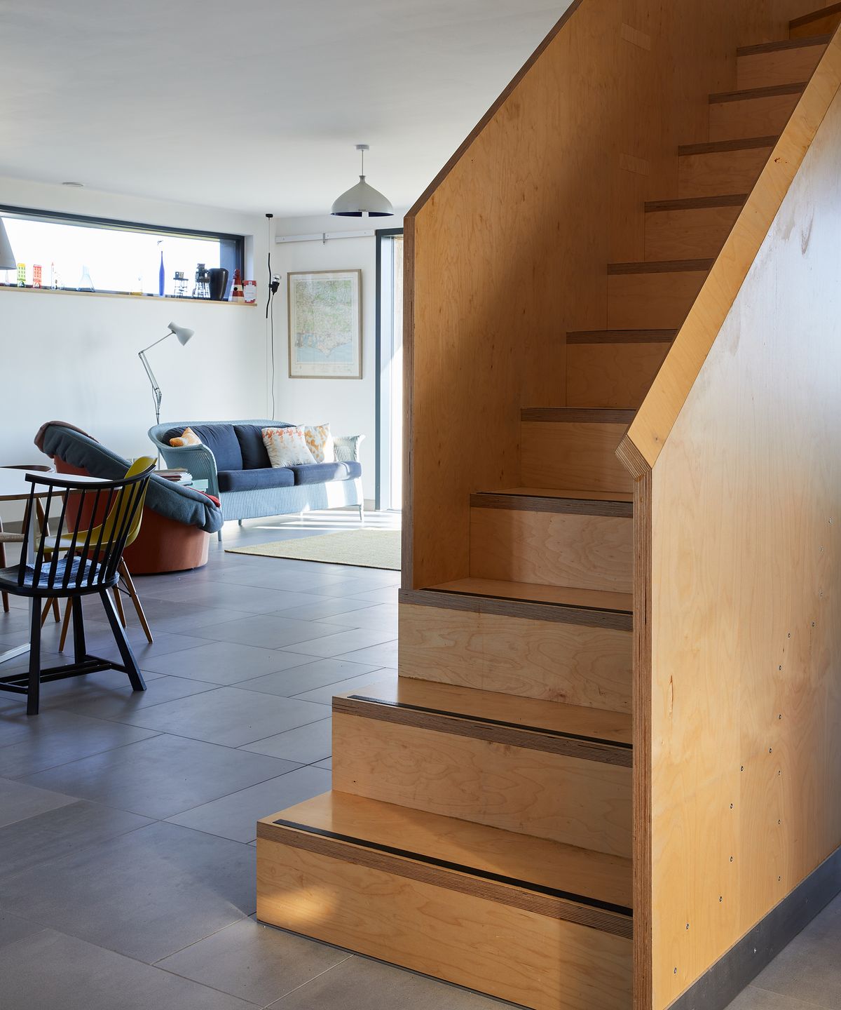 New staircase in the middle of a ground floor with an open plan living room and kitchen in view
