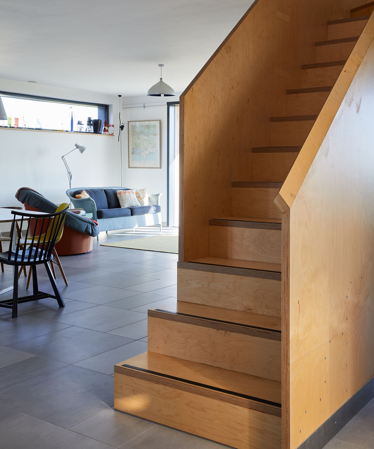 New staircase in the middle of a ground floor with an open plan living room and kitchen in view