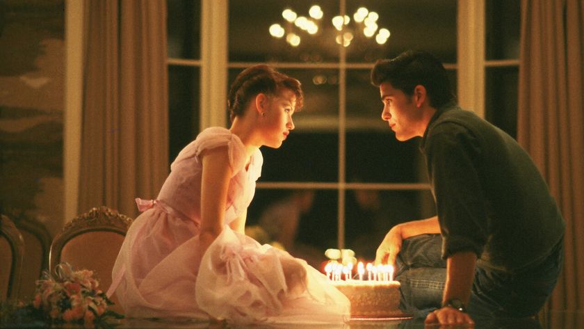 A still of Molly Ringwald and Michael Schoeffling sat on the table in Sixteen Candles 