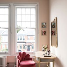 Light painted room with large open windows with white blinds, dressing table and chair