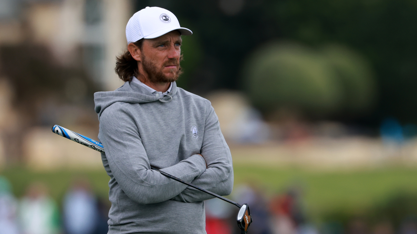 Tommy Fleetwood looks on holding a putter