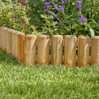 Wooden edging between a grassy lawn and a flower bed