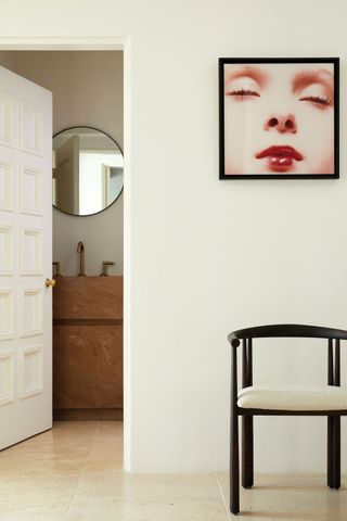 Hallway outside the bathroom with chair and contemporary artwork