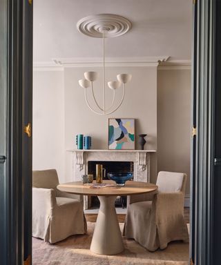 Modern dining room with round table and decorated mantel