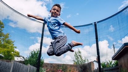 Boy jumping high on a trampoline