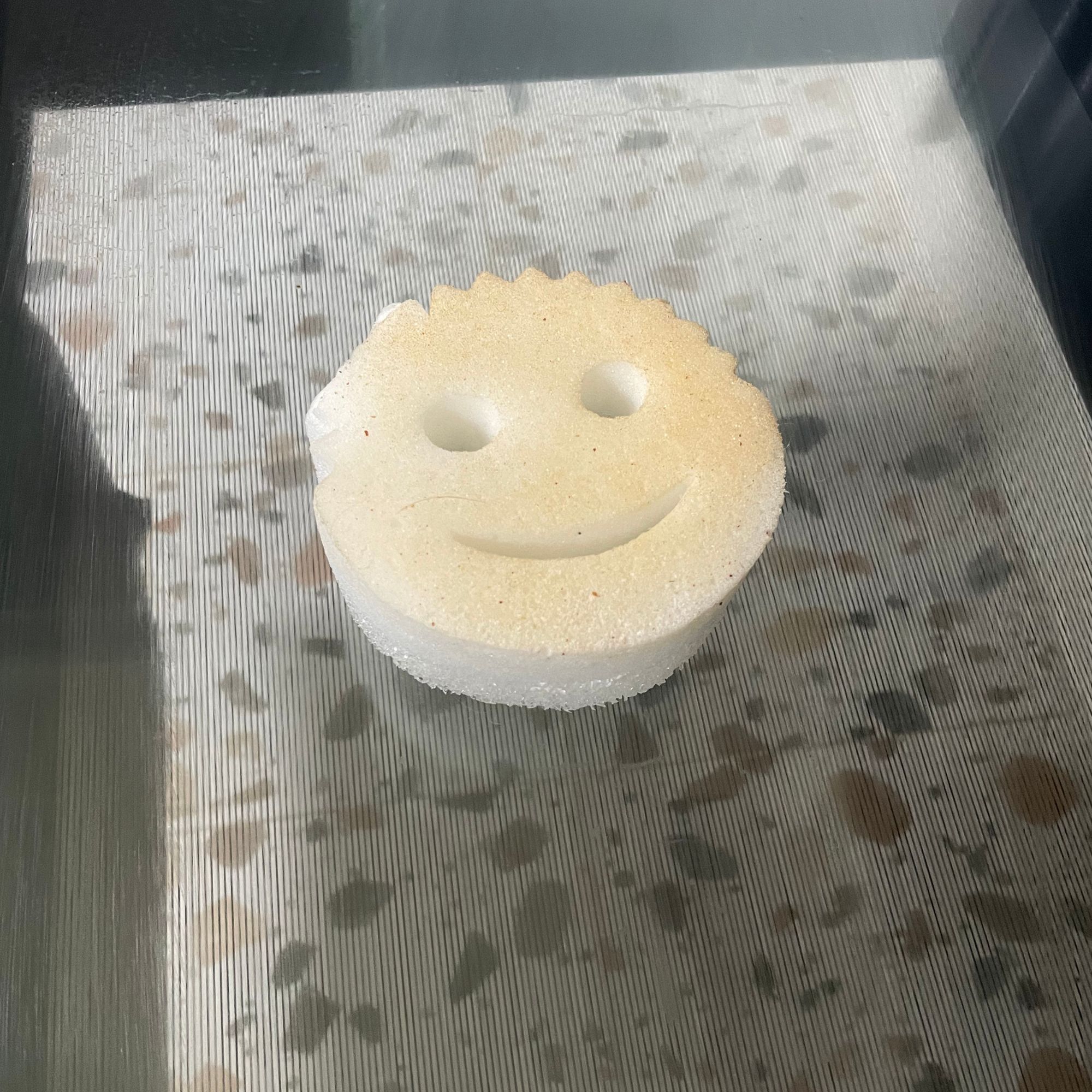 Dirty sponge of the Scrub Daddy Power Paste Multi Purpose Cleaner sitting on an oven door