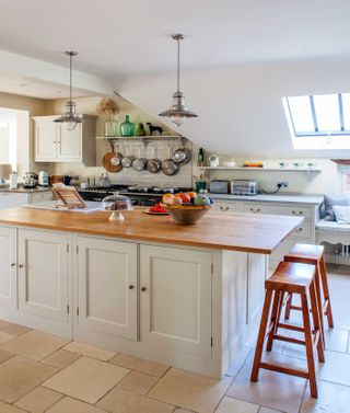 kitchen island with pans hanging above an aga