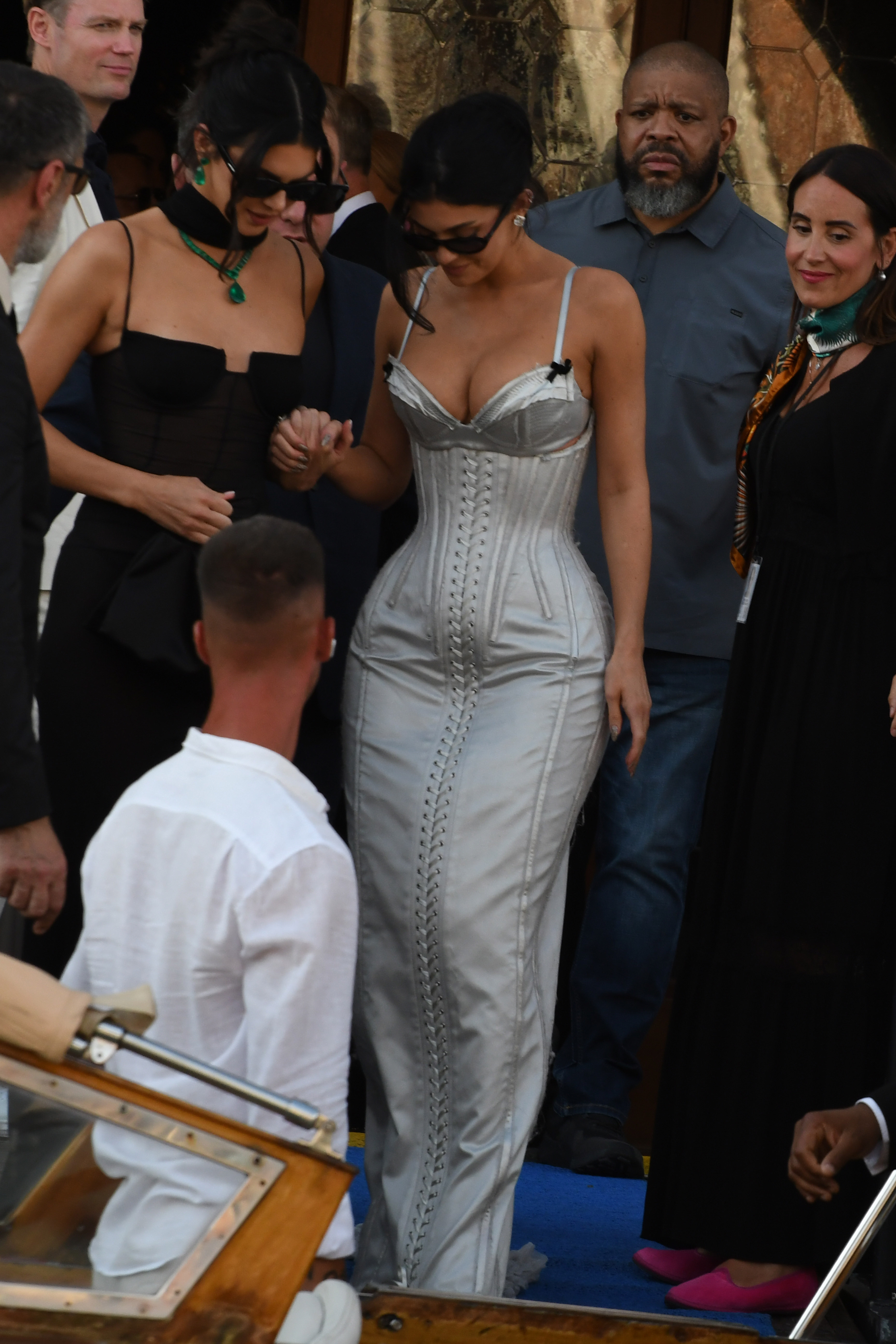 Kendall Jenner wears a sheer dress and Kylie Jenner wears a silver lace-up corset dress