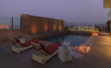 Sunset over a rooftop pool with sunloungers